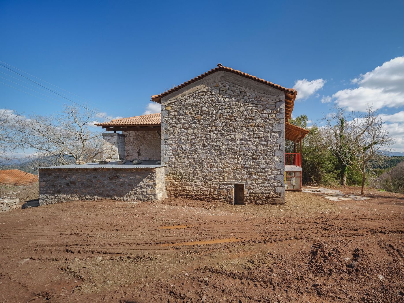 Neo-vernacular architecture emerges through careful preservation of original stone masonry paired with modern interventions. The composition reveals layers of architectural history, where traditional Mediterranean building techniques dialogue with contemporary spatial requirements in harmonious balance.