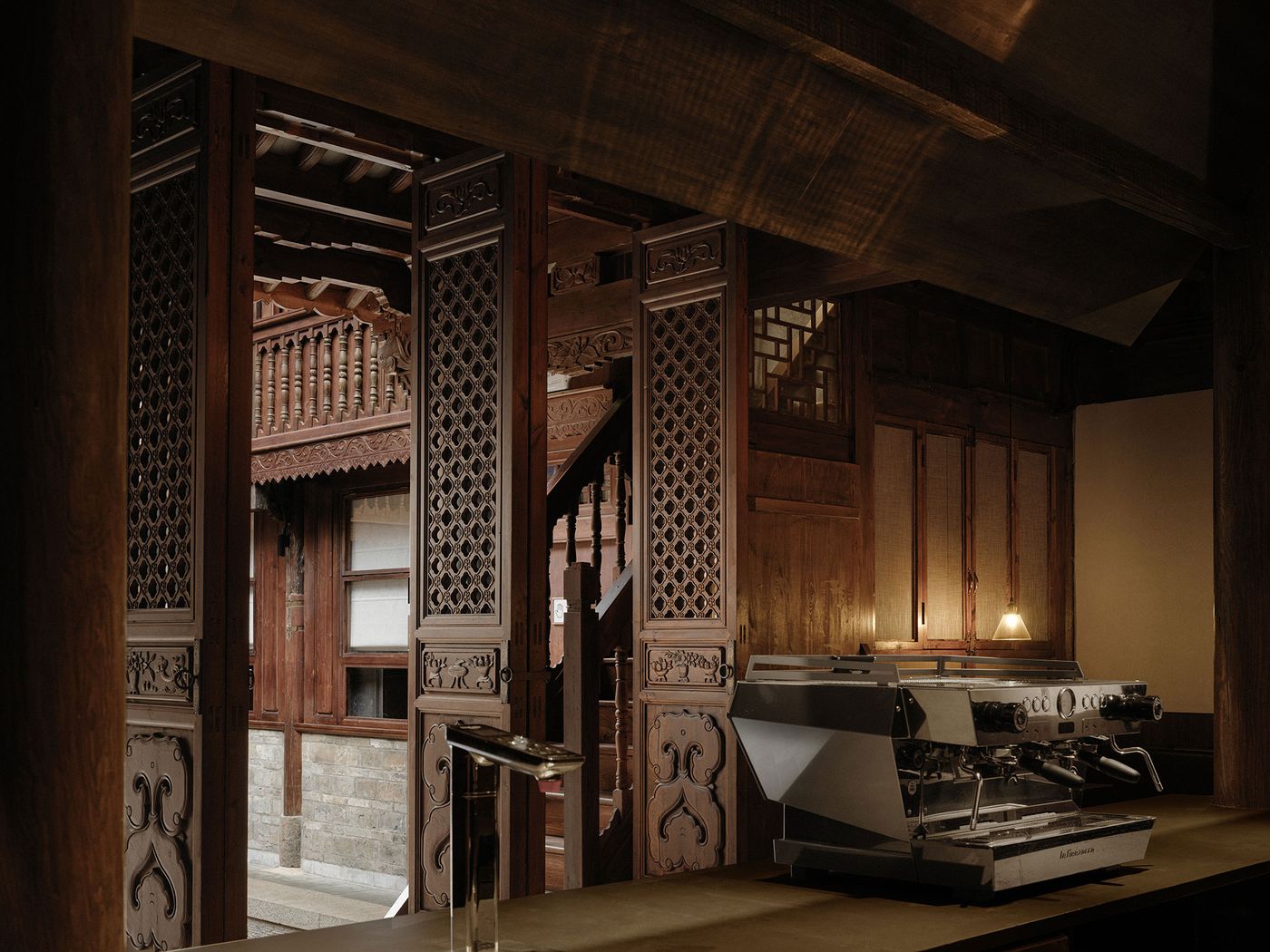 A beautifully crafted wooden interior with a vintage espresso machine, revealing intricate lattice doors and a traditional balcony view. A beautifully crafted wooden interior with a vintage espresso machine, revealing intricate lattice doors and a traditional balcony view.