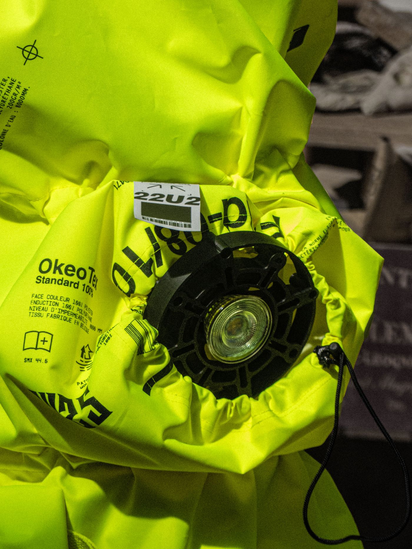 Close-up of a bright yellow inflatable flotation device with safety labels and a black circular mechanism on the side.