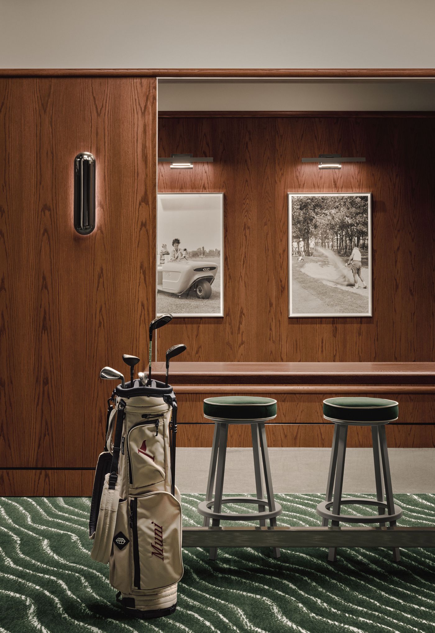 A stylish area featuring a golf bag, two green stools, and vintage photos against wooden paneling. A stylish area featuring a golf bag, two green stools, and vintage photos against wooden paneling.