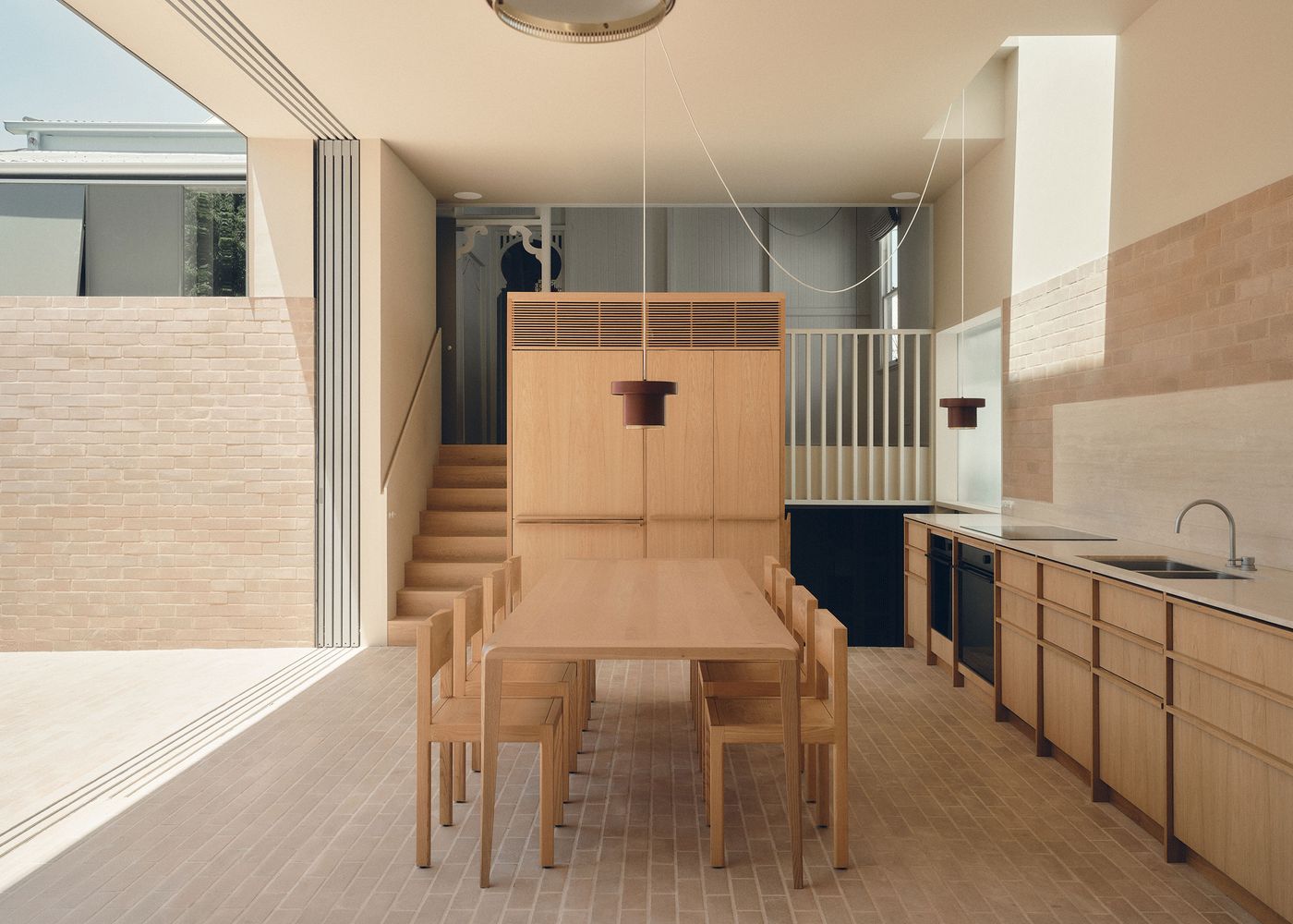 A modern, airy kitchen with wooden furniture, a large dining table, sleek cabinetry, and natural light illuminating the space. A modern, airy kitchen with wooden furniture, a large dining table, sleek cabinetry, and natural light illuminating the space.