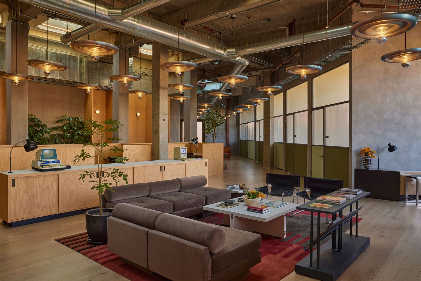 Modern office interior with sleek furniture, stylish lighting, and greenery, creating a welcoming and functional workspace. Modern office interior with sleek furniture, stylish lighting, and greenery, creating a welcoming and functional workspace.