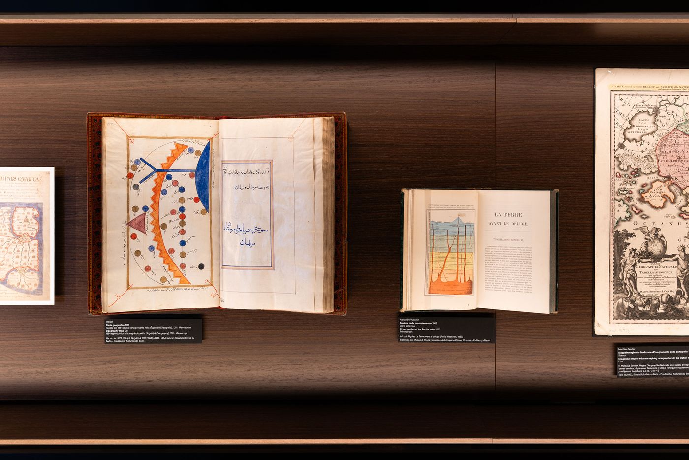 Three historical books displayed on a wooden shelf, featuring colorful illustrations and text in Arabic and French. Three historical books displayed on a wooden shelf, featuring colorful illustrations and text in Arabic and French.