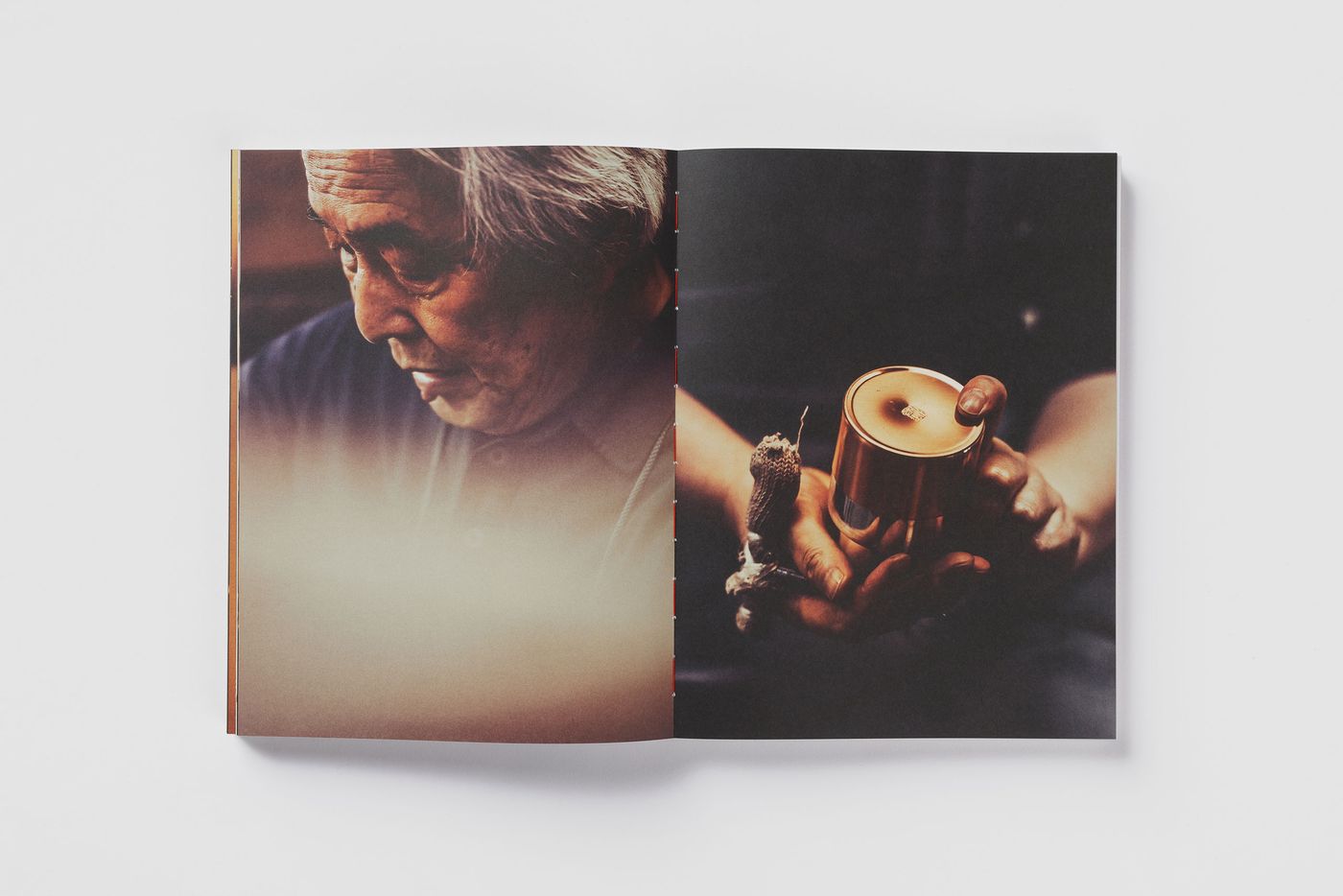 An open photo book showcasing hands holding a metallic candle on one page, with a blurred background creating a warm ambiance. An open photo book showcasing hands holding a metallic candle on one page, with a blurred background creating a warm ambiance.