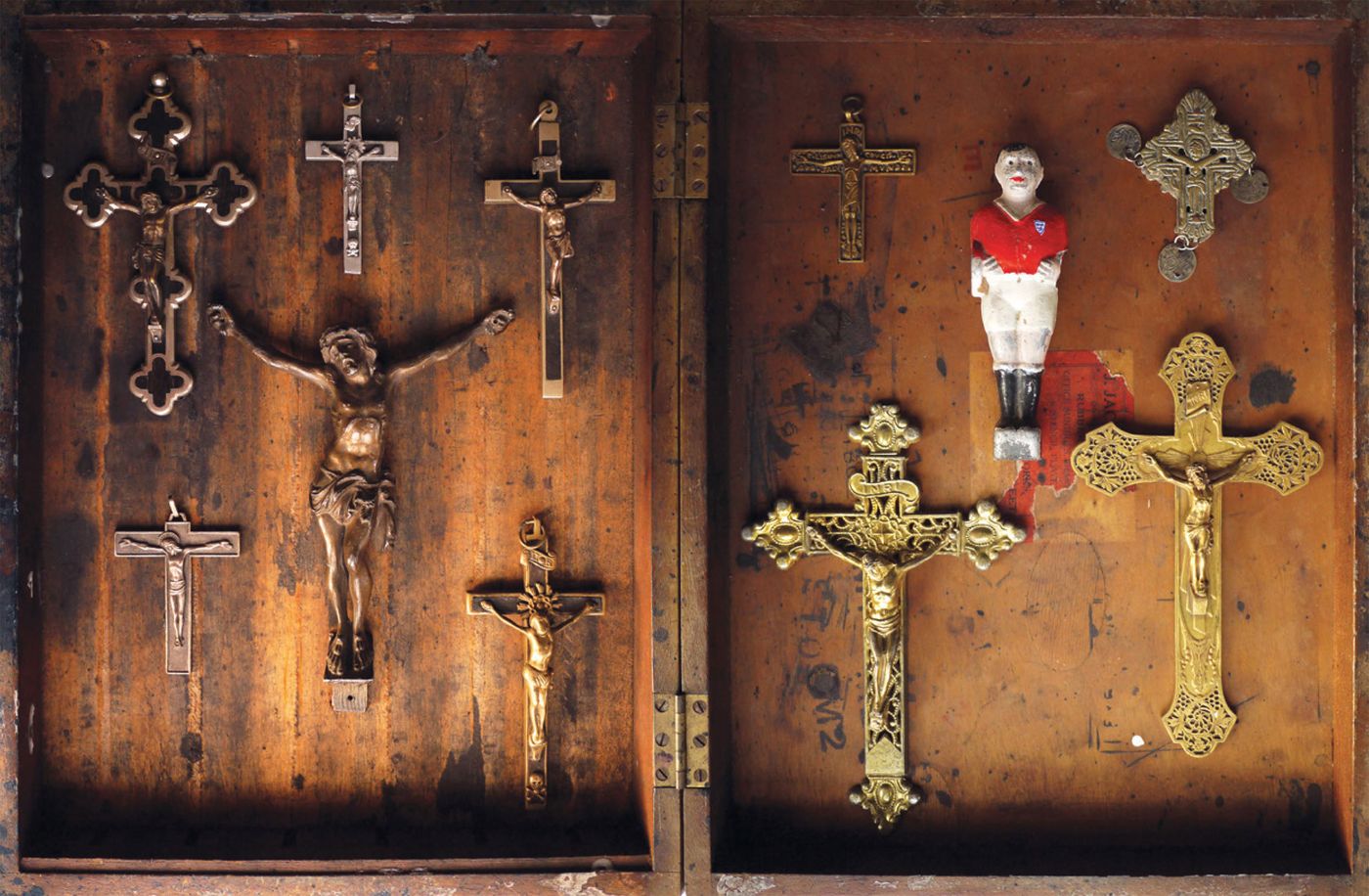 JESUS HE WAS A GOOD PLAYER by Ben Oakley 2012, 70 × 40 × 10 cm, Assorted crucifix and tin table footballer in wooden box. Courtesy of Tom Buchanan and 8 Books.