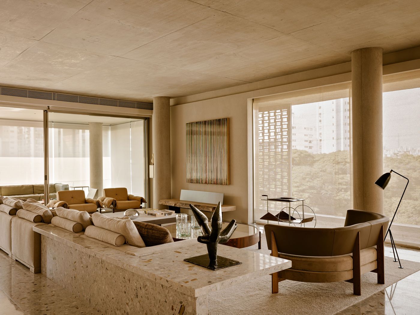 Modern living room with minimalist decor, featuring beige sofas, elegant art, wooden accents, and large windows inviting natural light. Modern living room with minimalist decor, featuring beige sofas, elegant art, wooden accents, and large windows inviting natural light.