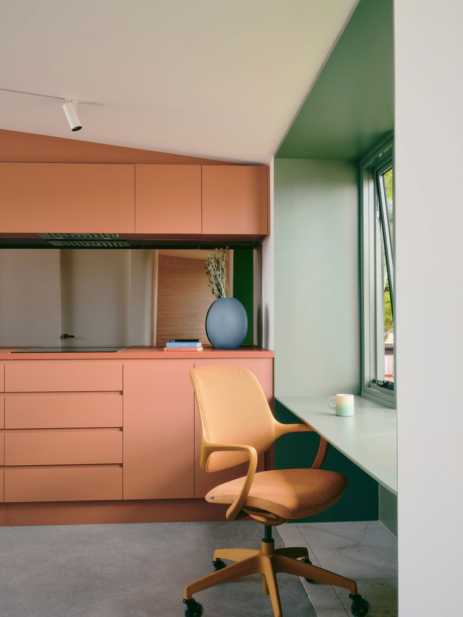 The workspace sits directly beside the terracotta kitchen, revealing how Carter Williamson Architects compress multiple functions into the studio’s modest footprint. A sage-green window recess forms the desk, while a cane-backed swivel chair, sculptural ceramic vase and restrained cabinetry create a warm, carefully composed contemporary interior. The workspace sits directly beside the terracotta kitchen, revealing how Carter Williamson Architects compress multiple functions into the studio’s modest footprint. A sage-green window recess forms the desk, while a cane-backed swivel chair, sculptural ceramic vase and restrained cabinetry create a warm, carefully composed contemporary interior.