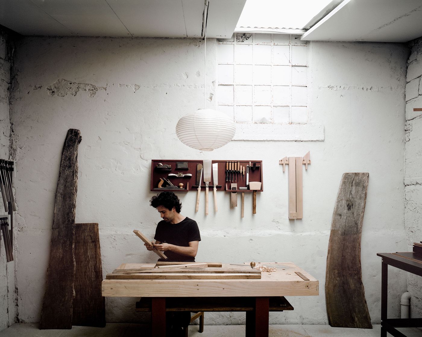 An artisan's workshop captures the essence of traditional woodworking, where weathered plaster walls frame a craftsperson at work. Hand tools hang precisely on the wall while natural light streams through industrial windows, creating an atmosphere of focused creativity and time-honored making processes. An artisan's workshop captures the essence of traditional woodworking, where weathered plaster walls frame a craftsperson at work. Hand tools hang precisely on the wall while natural light streams through industrial windows, creating an atmosphere of focused creativity and time-honored making processes.