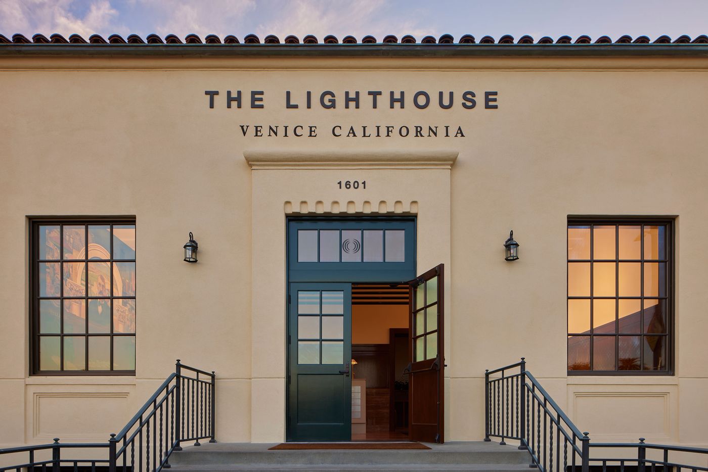 The entrance of The Lighthouse in Venice, California, featuring a green door, large windows, and modern architecture against a colorful sky. The entrance of The Lighthouse in Venice, California, featuring a green door, large windows, and modern architecture against a colorful sky.