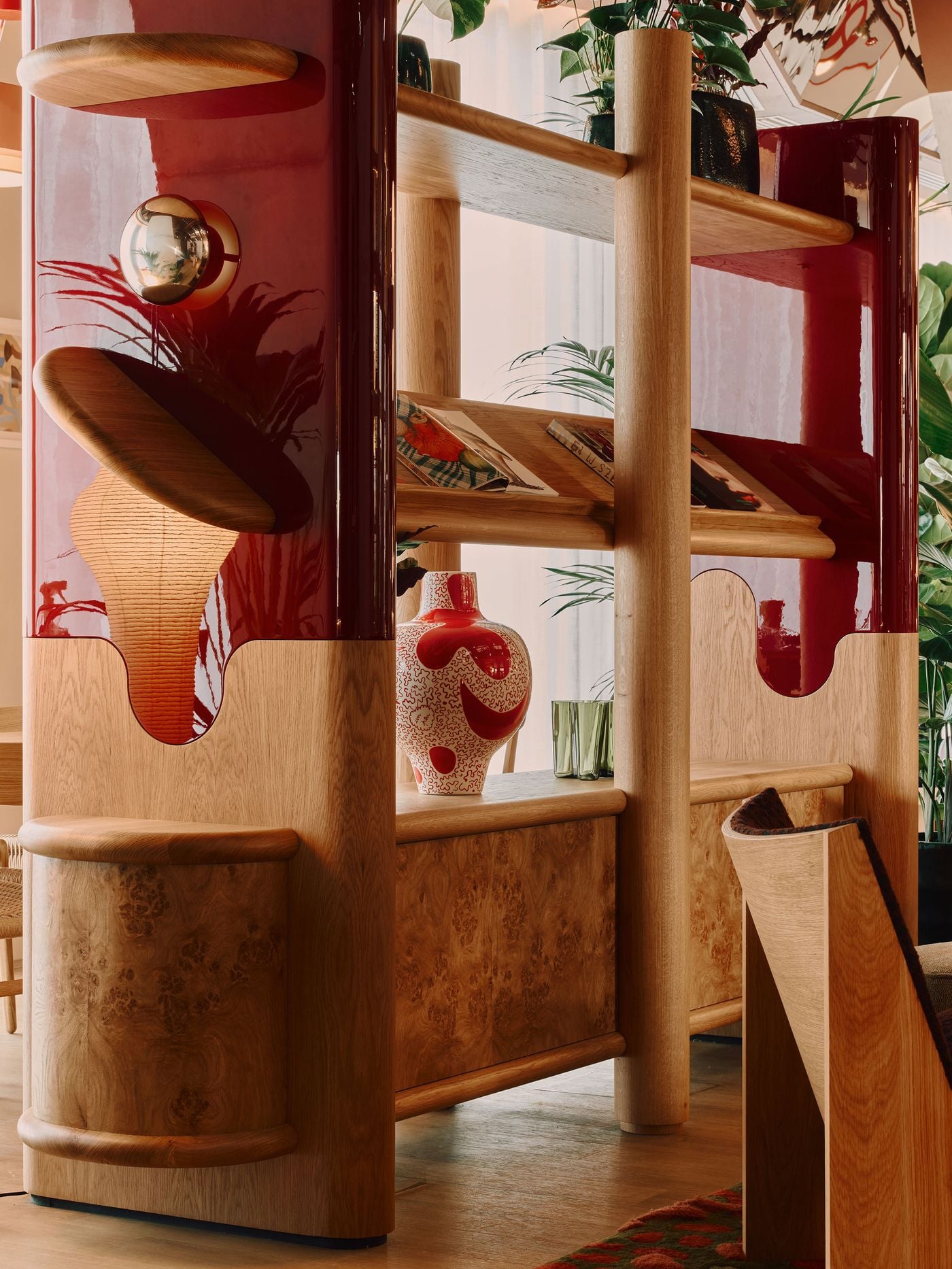 Holloway Li’s bespoke bookshelves combine pale timber, richly figured wood and high-gloss burgundy lacquer in a composition of rounded shelves and undulating cut-outs. Books, ceramics and integrated lighting turn the functional partition into a decorative focal point, its fluid geometry softening the hotel’s more rigid architectural framework. Holloway Li’s bespoke bookshelves combine pale timber, richly figured wood and high-gloss burgundy lacquer in a composition of rounded shelves and undulating cut-outs. Books, ceramics and integrated lighting turn the functional partition into a decorative focal point, its fluid geometry softening the hotel’s more rigid architectural framework.