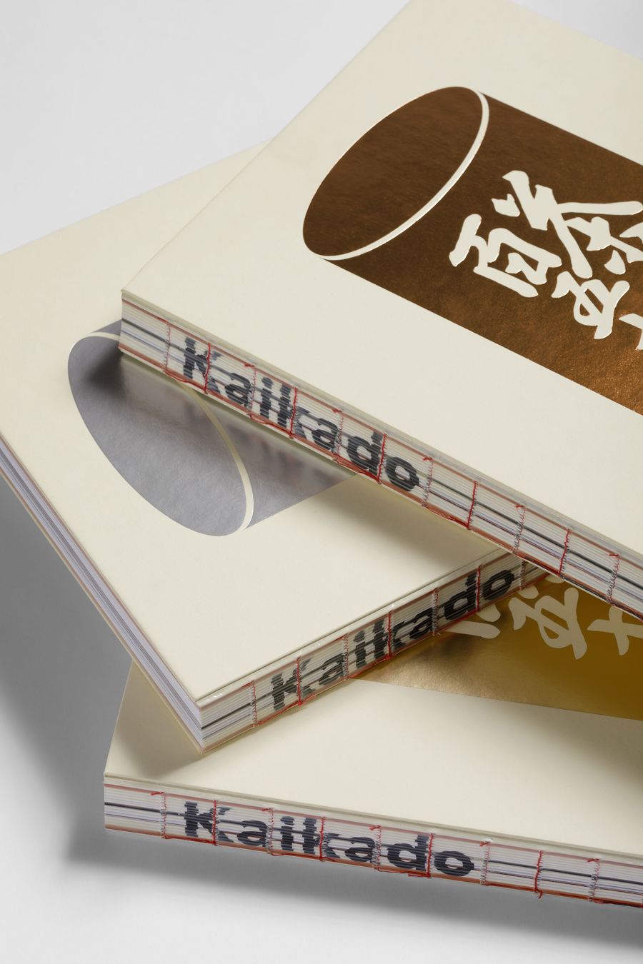 Three books stacked with cream covers and decorative elements, featuring gold foil and unique cut-out designs on the top book. Three books stacked with cream covers and decorative elements, featuring gold foil and unique cut-out designs on the top book.