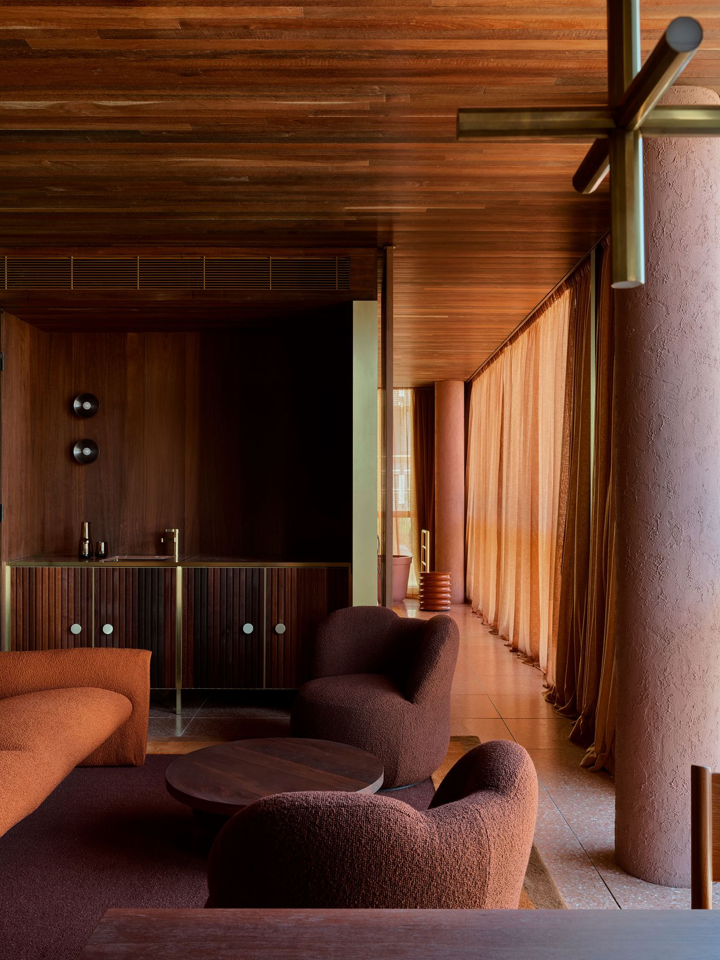 Stylish interior featuring cozy brown armchairs, a round table, and warm wooden textures, illuminated by soft natural light. Stylish interior featuring cozy brown armchairs, a round table, and warm wooden textures, illuminated by soft natural light.