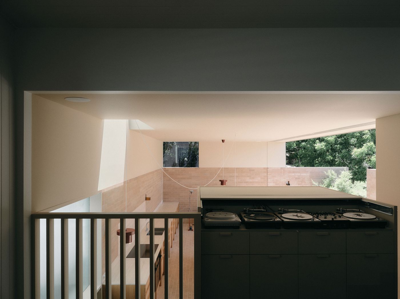 Modern kitchen with a sleek countertop, wooden dining table, and large windows allowing natural light and greenery to enter. Modern kitchen with a sleek countertop, wooden dining table, and large windows allowing natural light and greenery to enter.