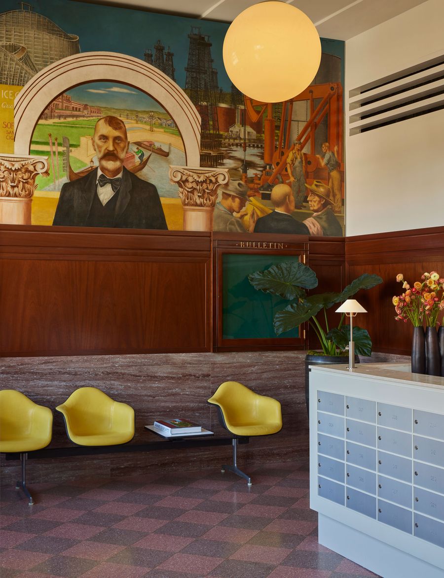 An elegant lobby featuring a vibrant mural, stylish yellow chairs, a modern lamp, and a bulletin board, evoking a vintage charm. An elegant lobby featuring a vibrant mural, stylish yellow chairs, a modern lamp, and a bulletin board, evoking a vintage charm.