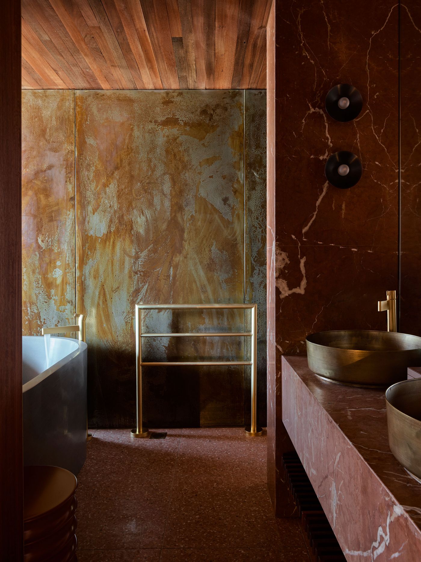 Luxurious bathroom featuring a freestanding tub, gold accents, and rich brown marble walls, complemented by wooden ceilings and stylish lighting. Luxurious bathroom featuring a freestanding tub, gold accents, and rich brown marble walls, complemented by wooden ceilings and stylish lighting.