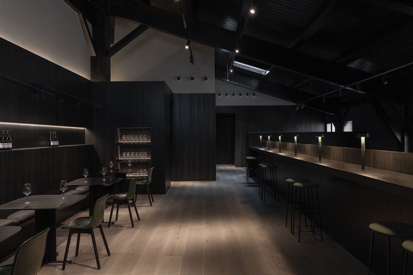 A sleek, modern interior of a bar featuring dark wood decor, stylish seating, and ambient lighting, creating an inviting atmosphere. A sleek, modern interior of a bar featuring dark wood decor, stylish seating, and ambient lighting, creating an inviting atmosphere.