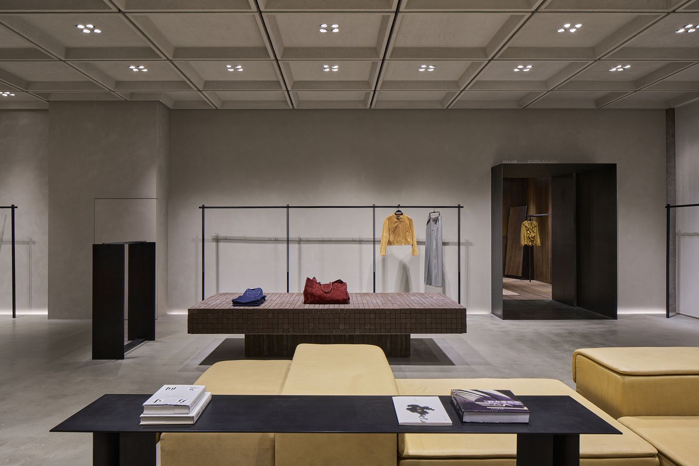 Modern boutique interior featuring minimalistic decor, a central display table, and elegantly hung clothing, with a subtle color palette. Modern boutique interior featuring minimalistic decor, a central display table, and elegantly hung clothing, with a subtle color palette.