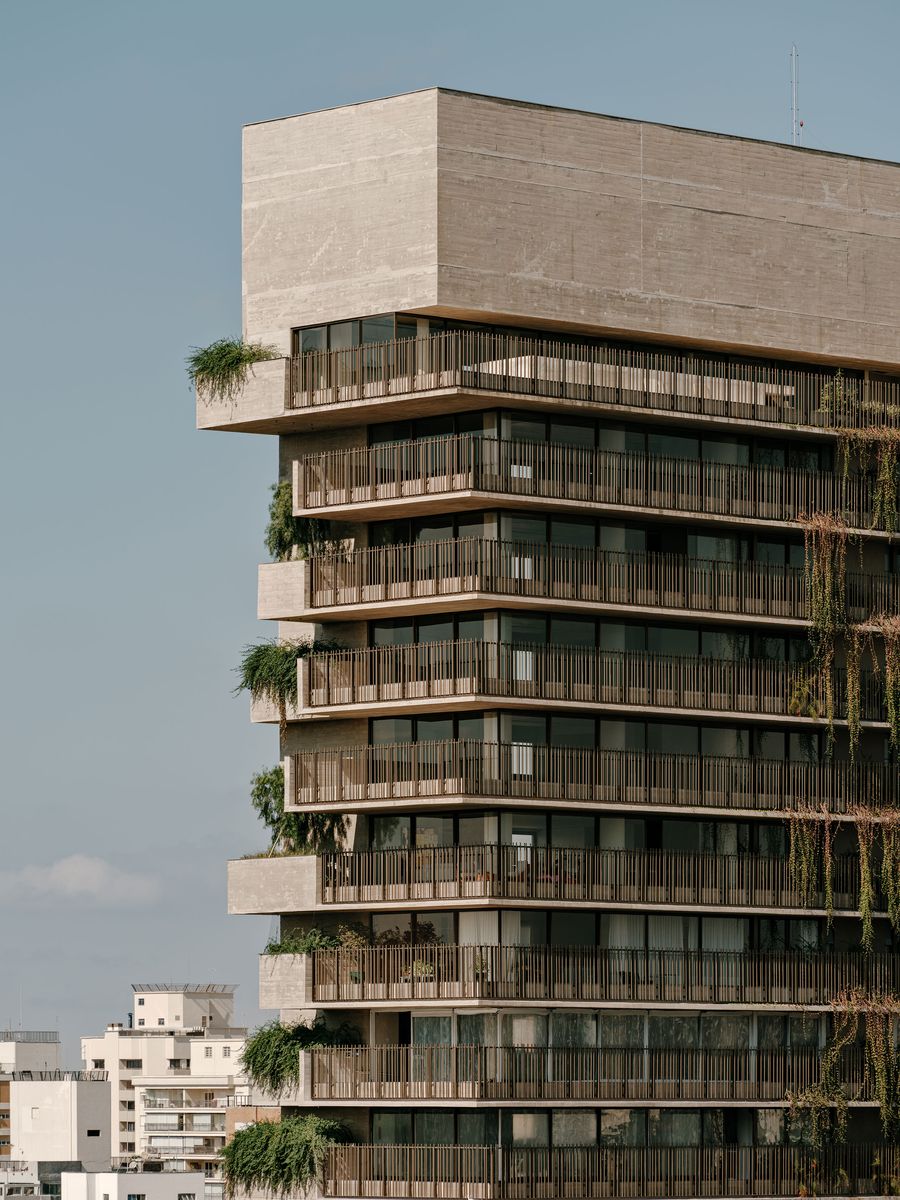 A detailed view of the upper sections of the tower, emphasizing the bold concrete massing of the penthouse level and the rhythmic pattern of the balconies below. Sparse but intentional greenery on some terraces adds a delicate touch, highlighting the building's refined brutalist aesthetic. A detailed view of the upper sections of the tower, emphasizing the bold concrete massing of the penthouse level and the rhythmic pattern of the balconies below. Sparse but intentional greenery on some terraces adds a delicate touch, highlighting the building's refined brutalist aesthetic.