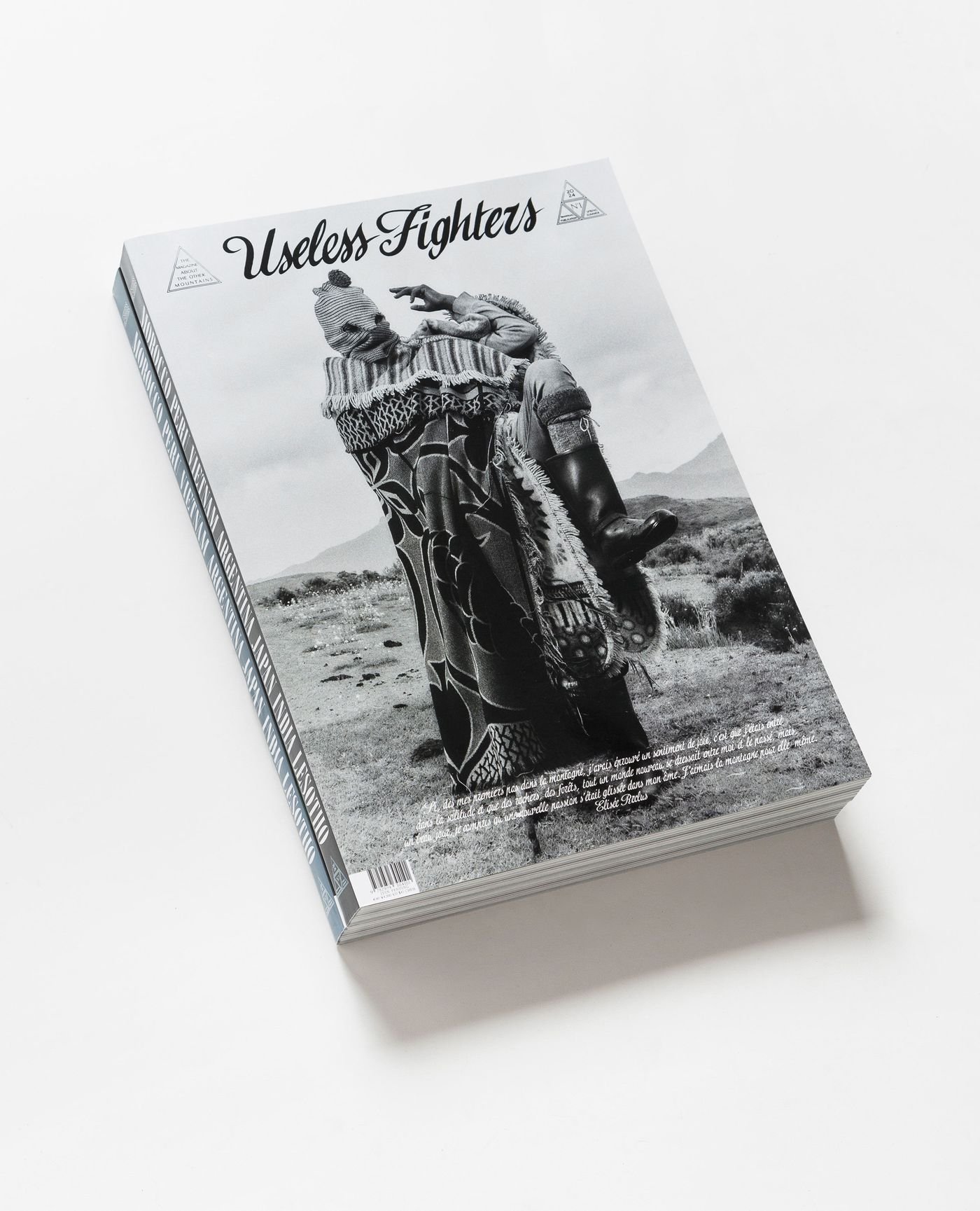 Close-up of the magazine "Useless Fighters," featuring a black-and-white cover photo of a figure wearing an ornate outfit in a landscape.