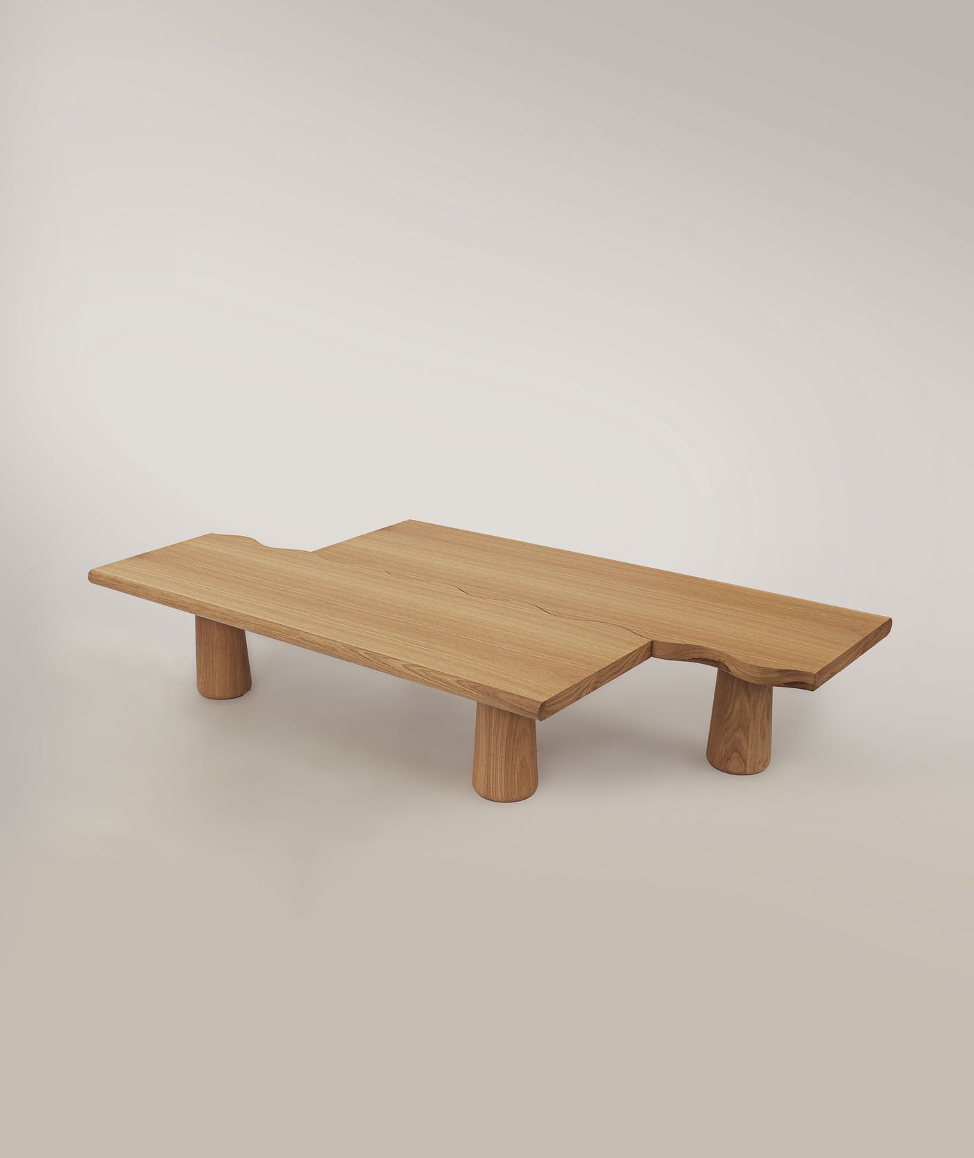 A minimalist wooden coffee table by Gonçalo Campos features an irregular, organic-shaped top crafted from light-toned wood. Supported by thick, cylindrical legs, its form is both playful and sculptural. The clean lines and natural material reflect a contemporary design sensibility, emphasizing craftsmanship and unique spatial presence. A minimalist wooden coffee table by Gonçalo Campos features an irregular, organic-shaped top crafted from light-toned wood. Supported by thick, cylindrical legs, its form is both playful and sculptural. The clean lines and natural material reflect a contemporary design sensibility, emphasizing craftsmanship and unique spatial presence.