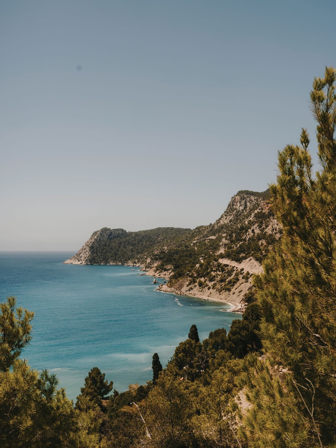 Scenic coastal view featuring turquoise waters, rocky cliffs, and lush greenery under a clear blue sky. Ideal for nature lovers. Scenic coastal view featuring turquoise waters, rocky cliffs, and lush greenery under a clear blue sky. Ideal for nature lovers.