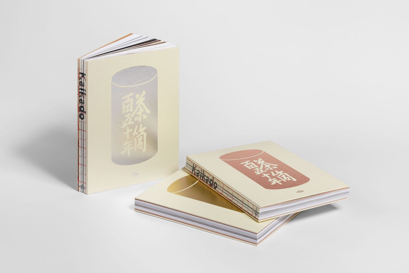 Three art books with soft covers, featuring minimalist designs and Asian typography, stacked on a white surface. Three art books with soft covers, featuring minimalist designs and Asian typography, stacked on a white surface.