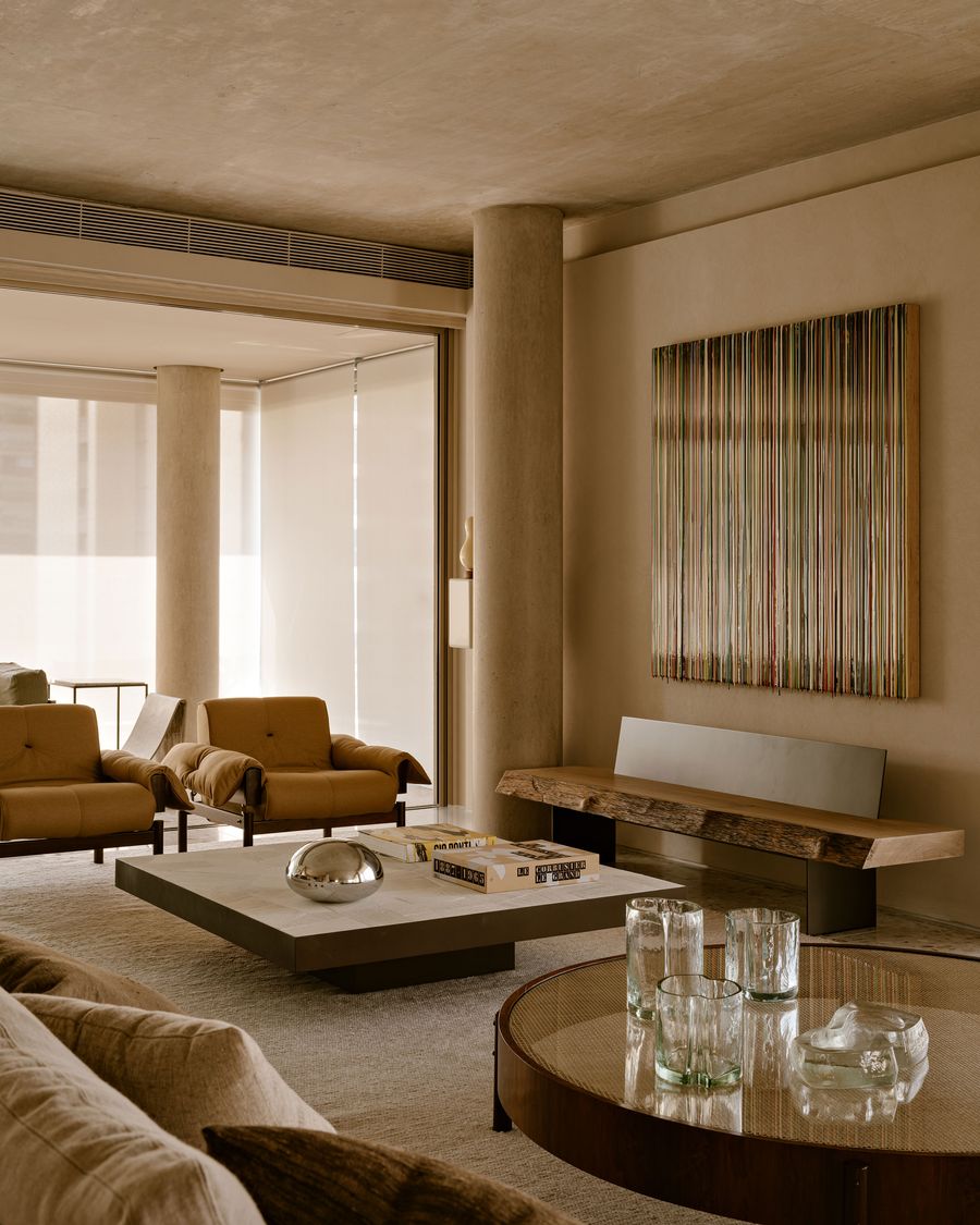 A modern living room with beige tones, featuring two armchairs, a sleek coffee table, and a vibrant striped artwork on the wall. A modern living room with beige tones, featuring two armchairs, a sleek coffee table, and a vibrant striped artwork on the wall.