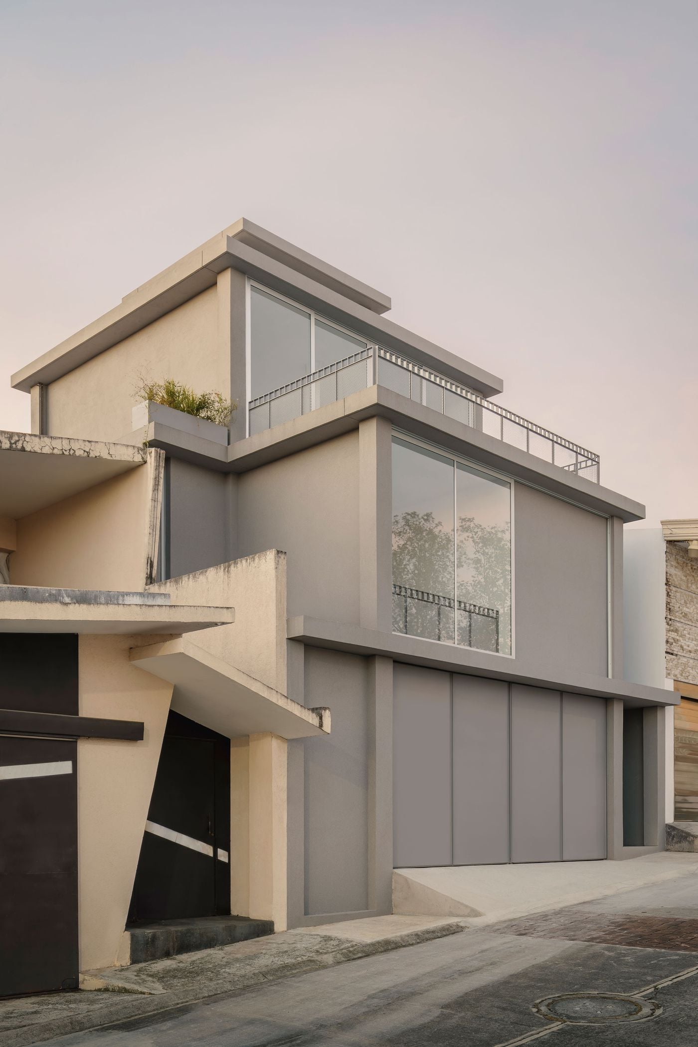Seen obliquely from the street, Casa Tlaloc’s stepped silhouette becomes especially apparent, with each grey volume receding from the one below. Deep horizontal slabs, floor-to-ceiling glazing and fine metal-mesh balustrades lighten the monolithic composition, contrasting with the warmer, more conventional houses alongside it. Seen obliquely from the street, Casa Tlaloc’s stepped silhouette becomes especially apparent, with each grey volume receding from the one below. Deep horizontal slabs, floor-to-ceiling glazing and fine metal-mesh balustrades lighten the monolithic composition, contrasting with the warmer, more conventional houses alongside it.