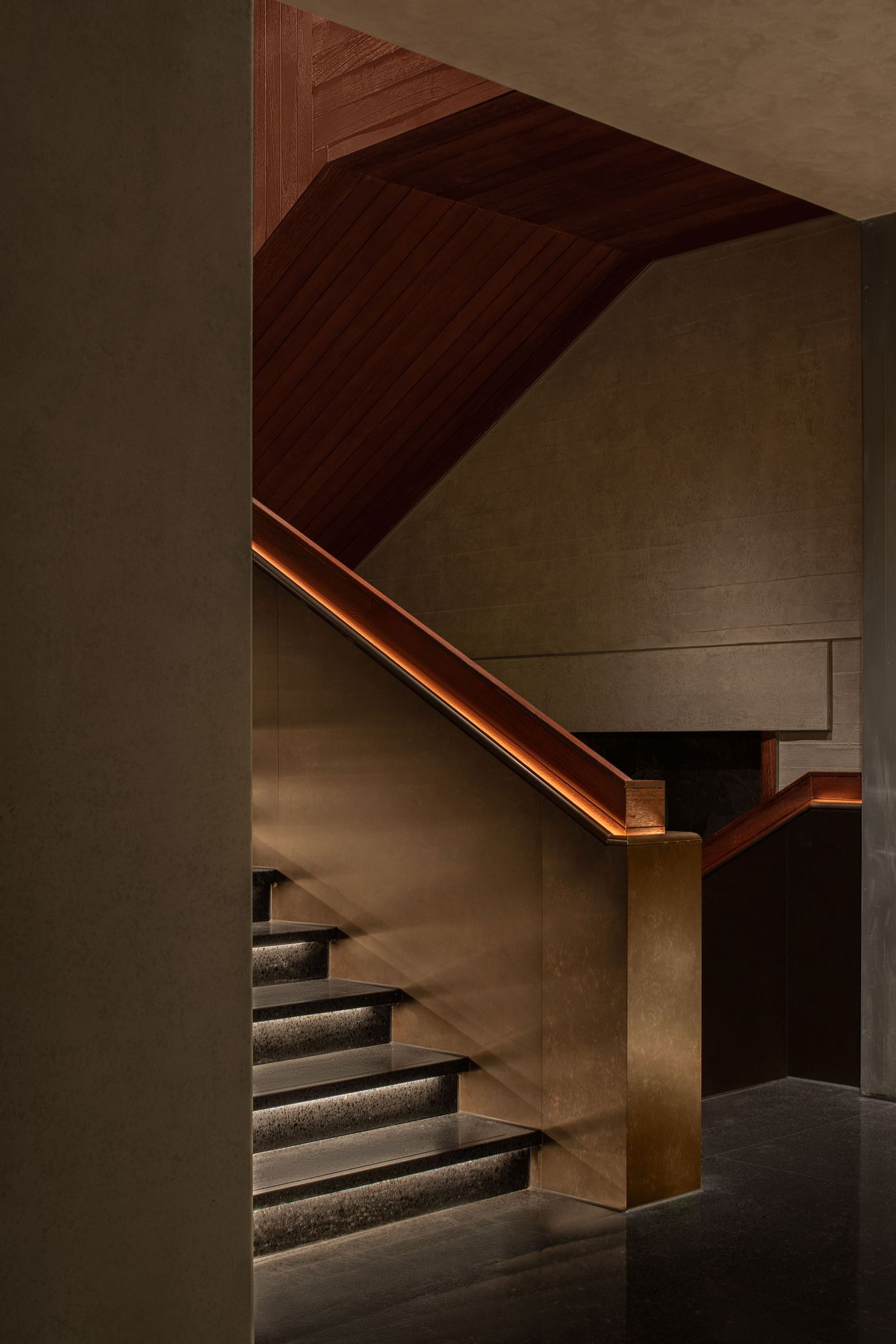 A modern staircase with sleek metal and wood accents, illuminated by subtle lighting, set against textured walls. A modern staircase with sleek metal and wood accents, illuminated by subtle lighting, set against textured walls.