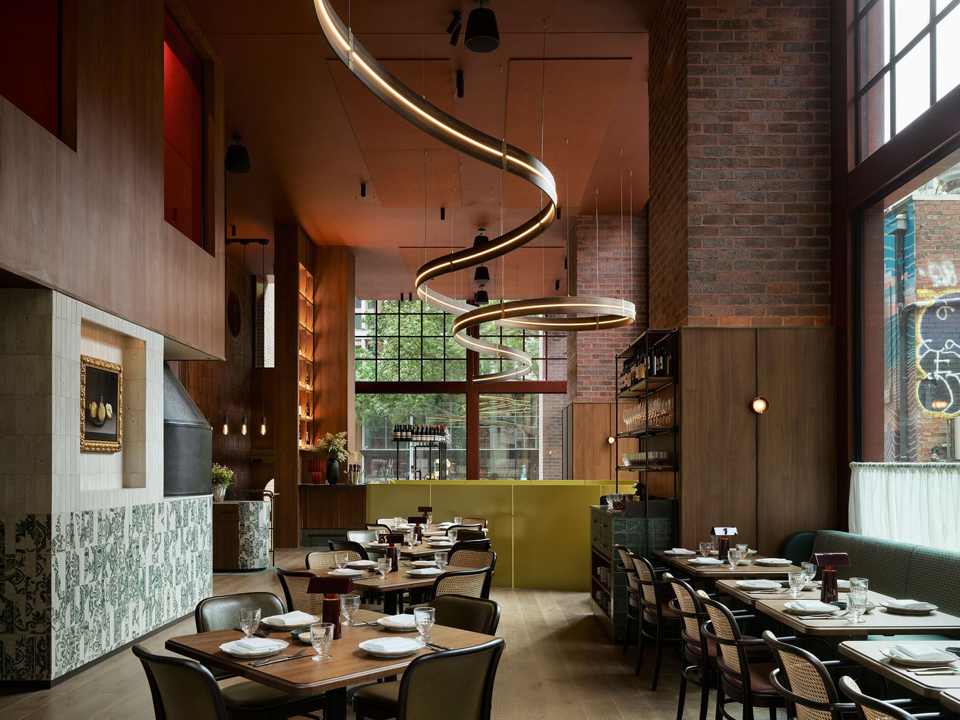 Stylish restaurant interior featuring wooden accents, unique spiral lighting, and elegantly set tables beside large windows. Stylish restaurant interior featuring wooden accents, unique spiral lighting, and elegantly set tables beside large windows.