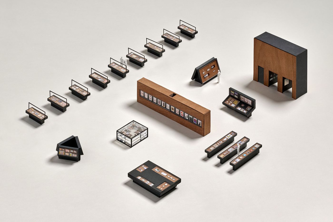 A layout of miniature exhibition displays, featuring various art pieces and a small figure, on a neutral background. A layout of miniature exhibition displays, featuring various art pieces and a small figure, on a neutral background.