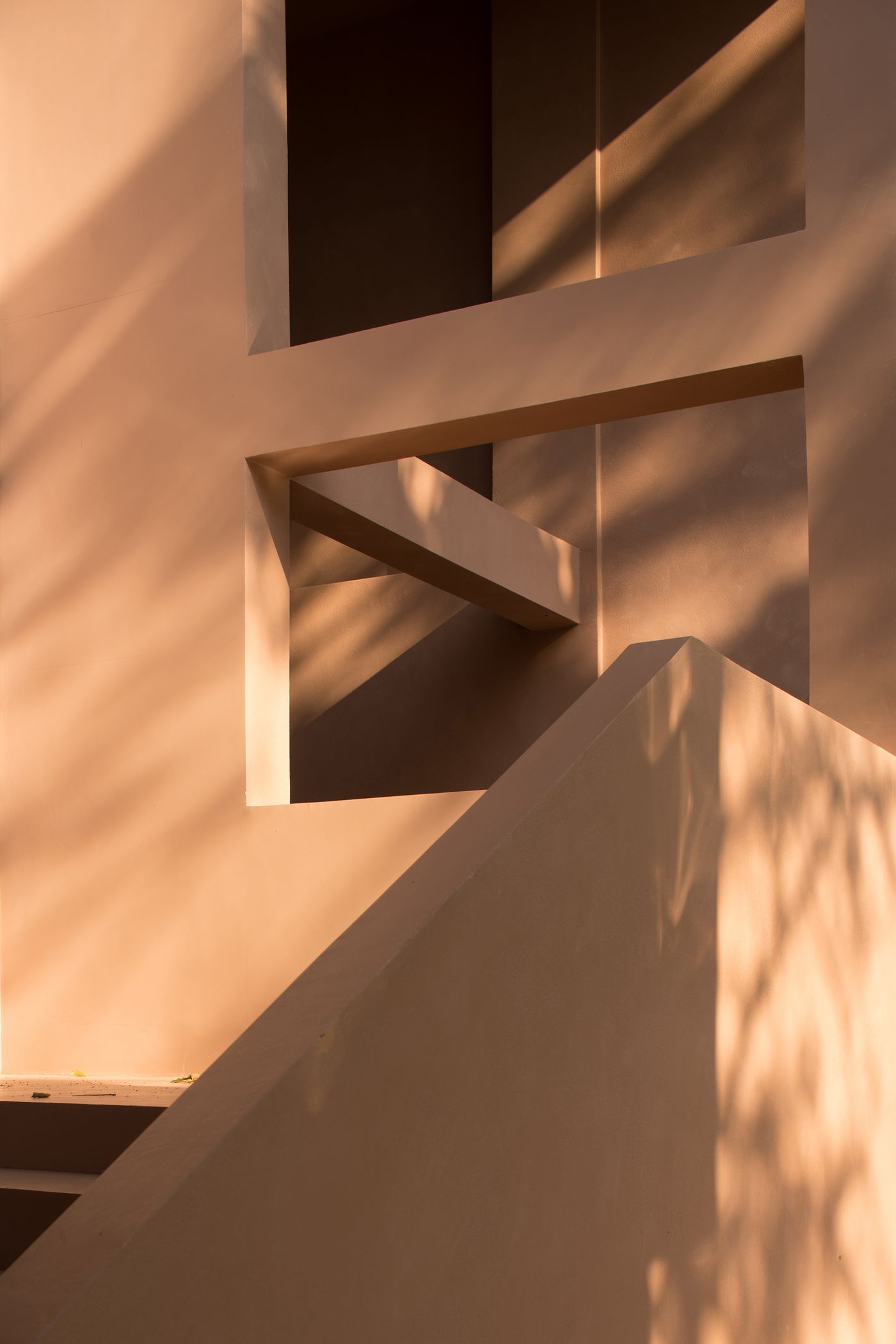 Abstract architectural details with peach-toned walls, sharp angles, and soft shadows creating depth and texture.