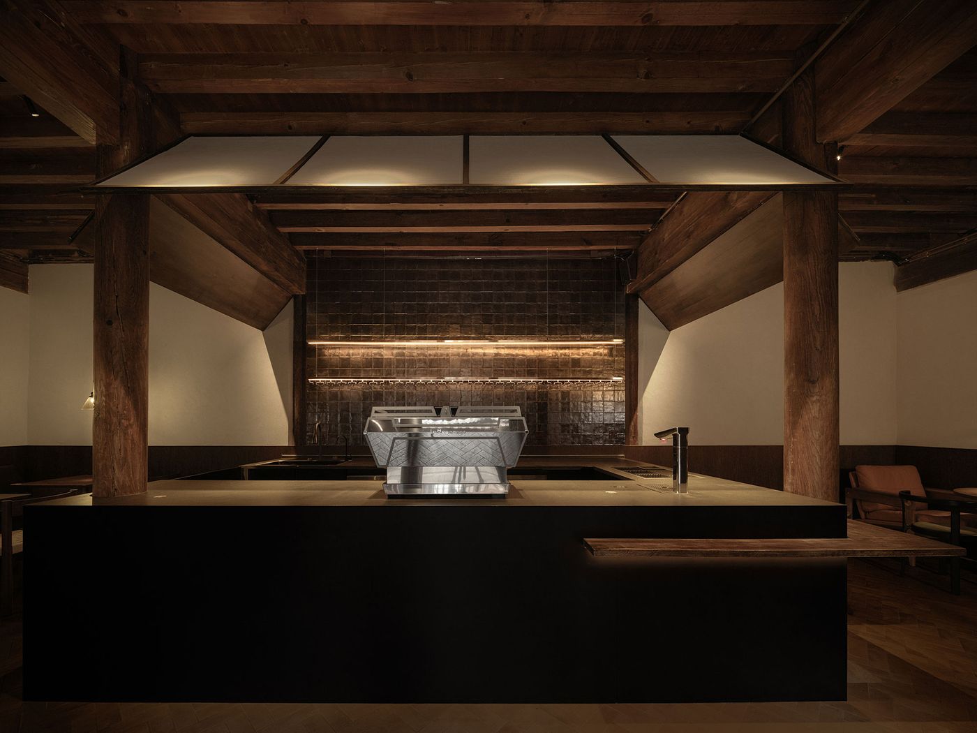 Minimalist coffee shop interior featuring a sleek counter, wooden beams, spot lighting, and a modern espresso machine. Minimalist coffee shop interior featuring a sleek counter, wooden beams, spot lighting, and a modern espresso machine.