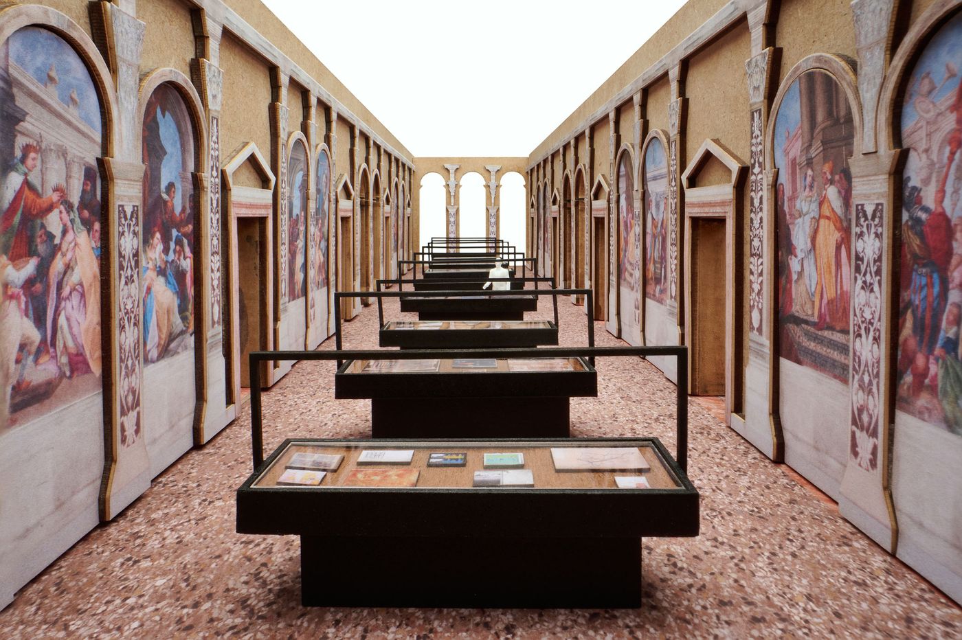 A miniature of a long gallery that features glass display cases and mural-adorned walls, showcasing artwork and historical artifacts. A miniature of a long gallery that features glass display cases and mural-adorned walls, showcasing artwork and historical artifacts.