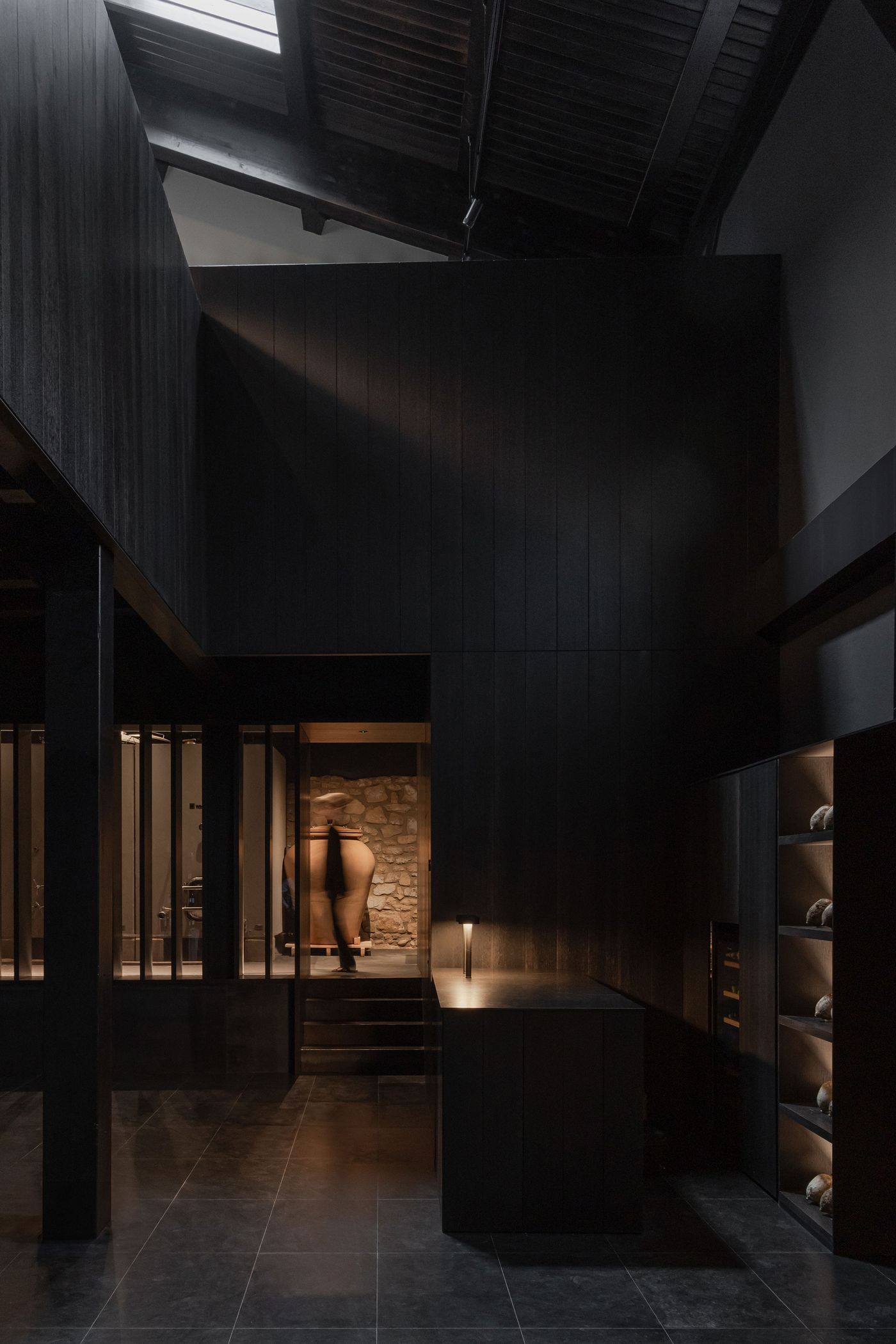 A modern interior with dark wood walls, stone accents, and a large ceramic vase, illuminated by soft lighting. A modern interior with dark wood walls, stone accents, and a large ceramic vase, illuminated by soft lighting.