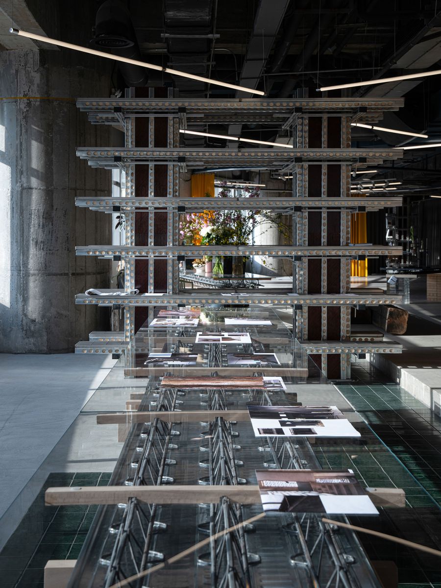 A perspective shot within 889 GLO Art Space emphasizes the intricate, multi-level display structure. Crafted from industrial metal elements, it features various art pieces and publications. The raw concrete pillar and exposed ceiling, combined with the reflective surfaces and curated displays, exemplify a sophisticated industrial design with an artistic edge. A perspective shot within 889 GLO Art Space emphasizes the intricate, multi-level display structure. Crafted from industrial metal elements, it features various art pieces and publications. The raw concrete pillar and exposed ceiling, combined with the reflective surfaces and curated displays, exemplify a sophisticated industrial design with an artistic edge.