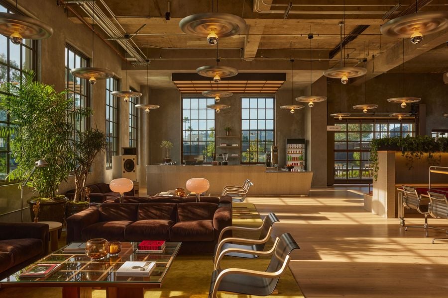 Modern café interior featuring a sleek bar, unique lighting, and cozy seating, with large windows illuminating the space.