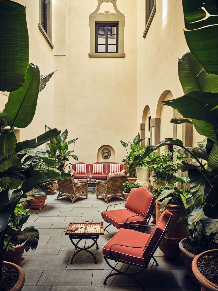 A lion's-head fountain set into a niche watches over the courtyard at La Réserve Firenze, where coral-cushioned iron chairs, wicker armchairs and a striped sofa gather among banana plants in terracotta pots. A backgammon set on a folding table and a window with a scrolled stone surround suggest long, unhurried afternoons. A lion's-head fountain set into a niche watches over the courtyard at La Réserve Firenze, where coral-cushioned iron chairs, wicker armchairs and a striped sofa gather among banana plants in terracotta pots. A backgammon set on a folding table and a window with a scrolled stone surround suggest long, unhurried afternoons.