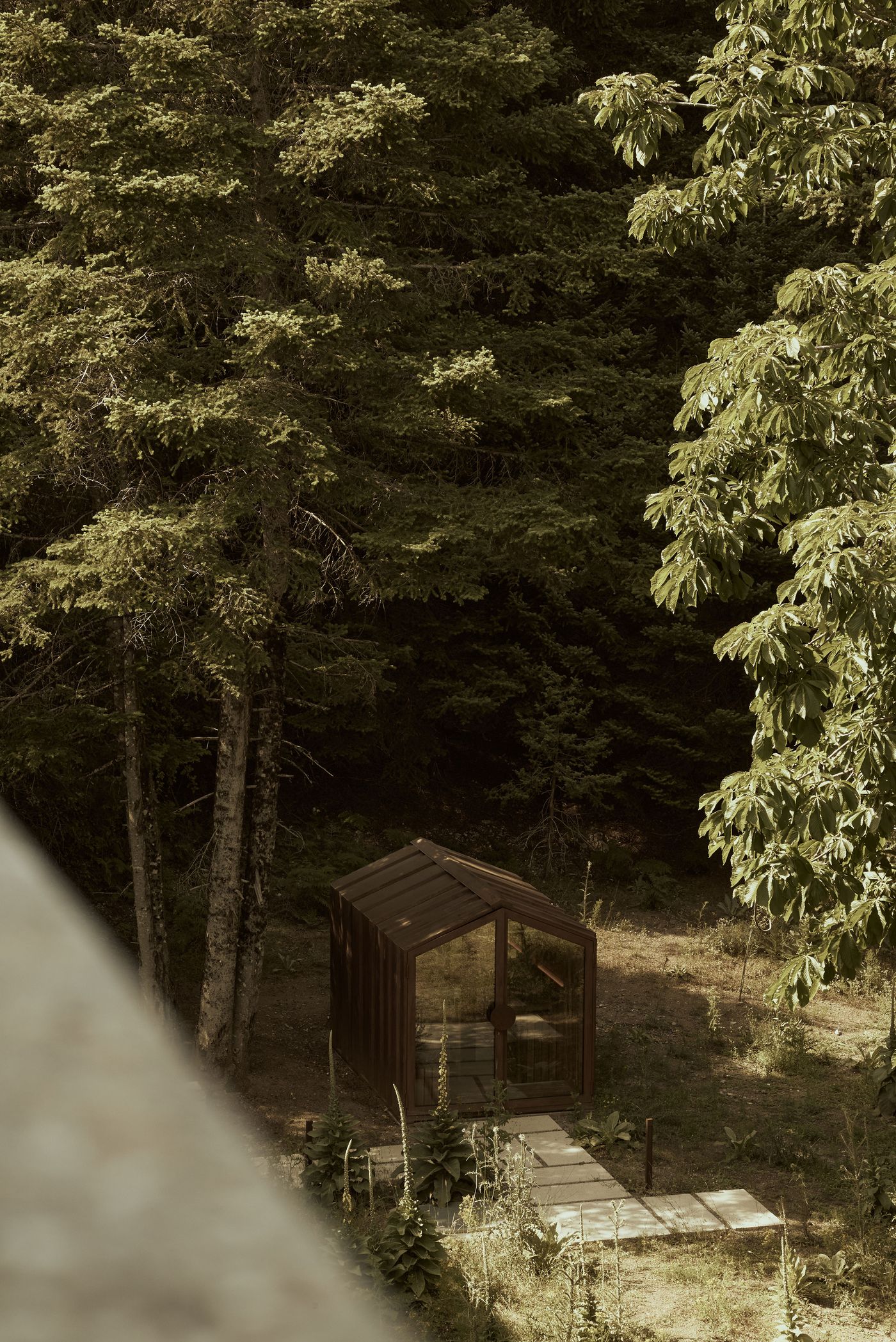 A charming, modern-rustic sauna hut with a clear glass facade and dark timber framing sits nestled at the edge of a dense pine forest. A simple stone pathway leads to its entrance, suggesting a secluded wellness experience deeply integrated into the tranquil natural surroundings. A charming, modern-rustic sauna hut with a clear glass facade and dark timber framing sits nestled at the edge of a dense pine forest. A simple stone pathway leads to its entrance, suggesting a secluded wellness experience deeply integrated into the tranquil natural surroundings.