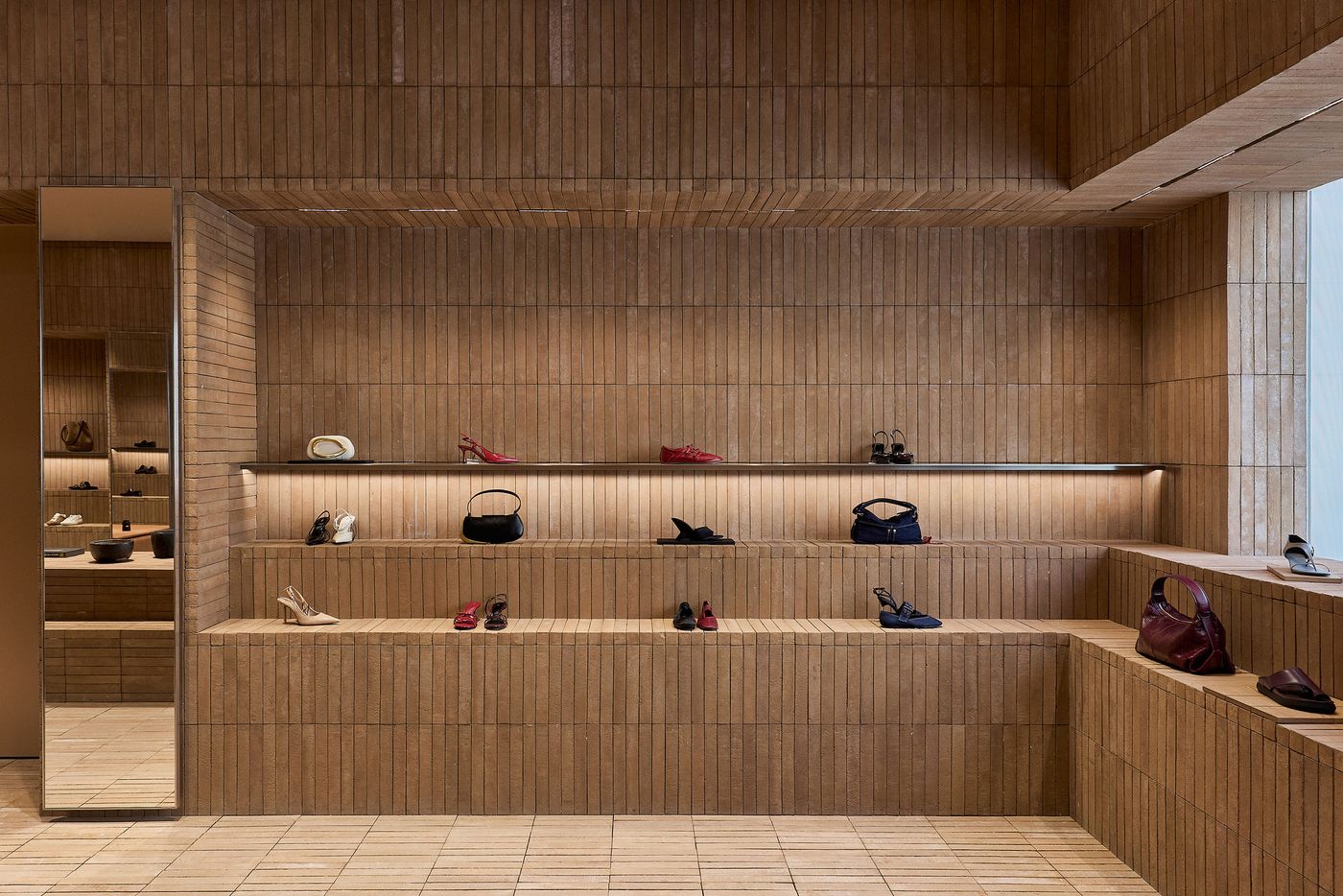 A minimalist shoe display wall with wooden textures, featuring various styles of shoes and handbags illuminated by soft lighting. A minimalist shoe display wall with wooden textures, featuring various styles of shoes and handbags illuminated by soft lighting.