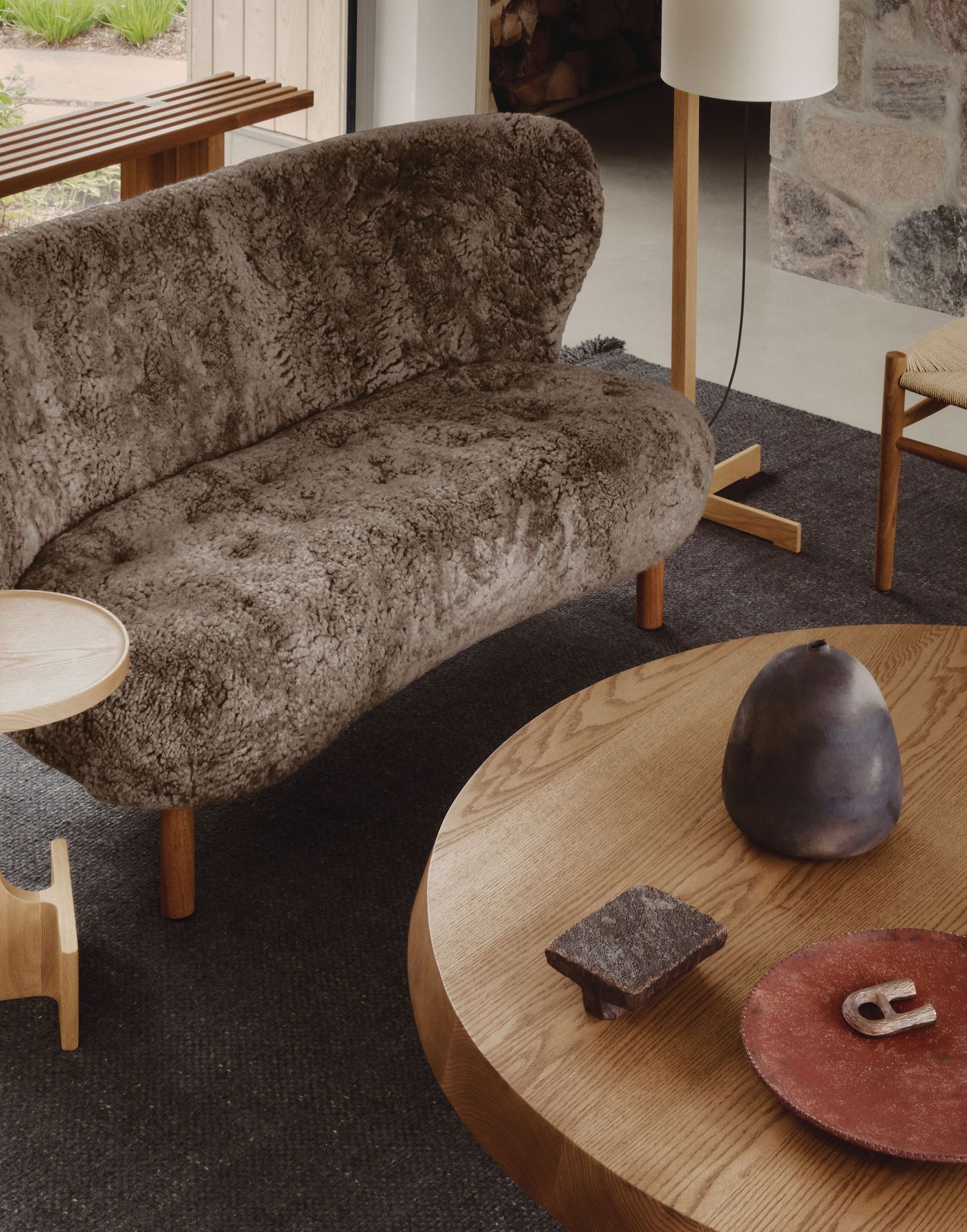 A cozy interior featuring a plush, brown sofa, wooden tables, and decorative items on a dark rug, creating a warm, inviting atmosphere. A cozy interior featuring a plush, brown sofa, wooden tables, and decorative items on a dark rug, creating a warm, inviting atmosphere.