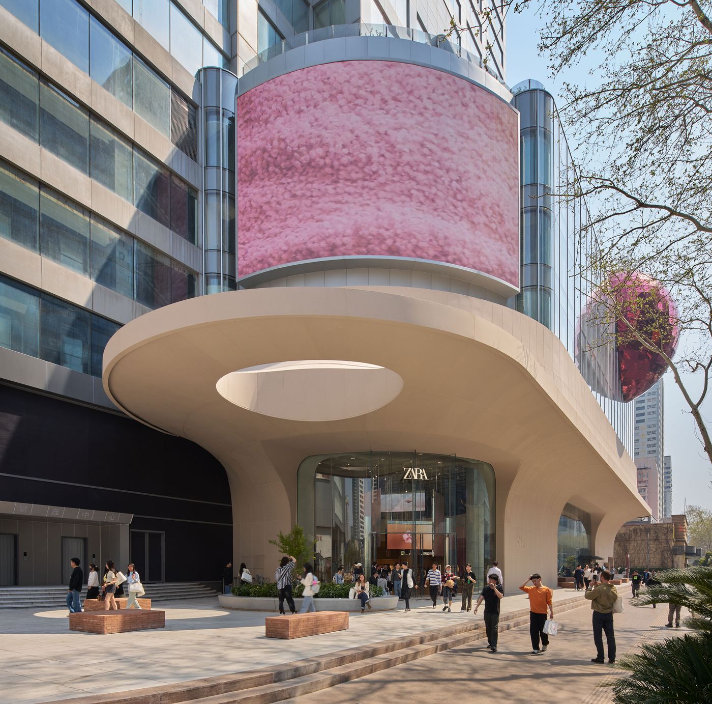 Modern storefront of Zara featuring a large digital screen and unique architectural design, with people walking and enjoying the scene. Modern storefront of Zara featuring a large digital screen and unique architectural design, with people walking and enjoying the scene.