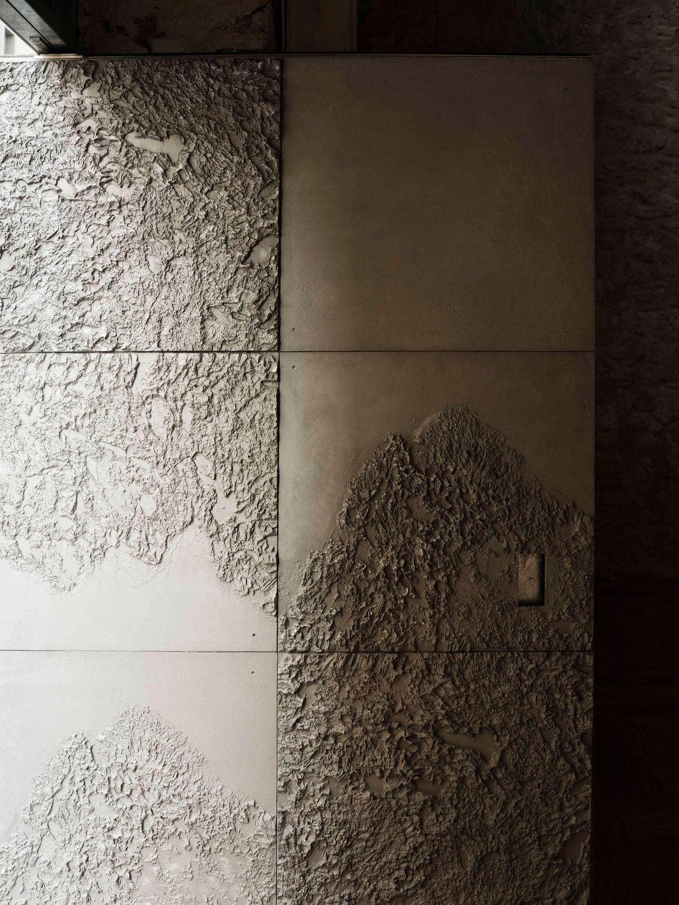 A close-up of Castor Place’s custom-made doors reveal smooth and textured metal panels, creating an irregular relief that echoes the texture of the building’s exposed masonry. Raking light accentuates the contrast between raw, granular surfaces and precisely joined panels. A close-up of Castor Place’s custom-made doors reveal smooth and textured metal panels, creating an irregular relief that echoes the texture of the building’s exposed masonry. Raking light accentuates the contrast between raw, granular surfaces and precisely joined panels.