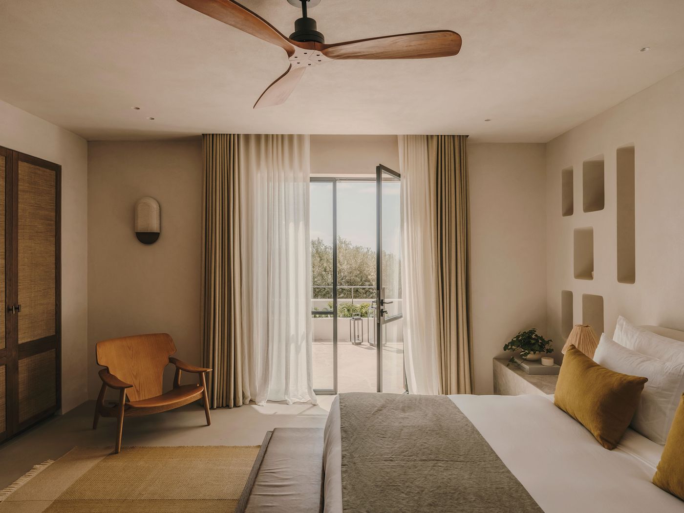Modern, serene bedroom with a bed, wooden chair, and open balcony door, letting in natural light and greenery. Minimalist decor and warm colors. Modern, serene bedroom with a bed, wooden chair, and open balcony door, letting in natural light and greenery. Minimalist decor and warm colors.