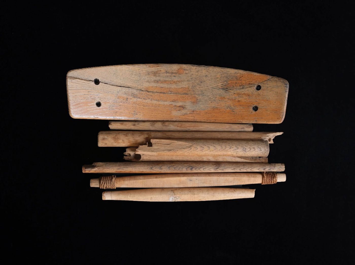 A collection of wooden tools and rods arranged on a black background, showcasing various shapes and textures. A collection of wooden tools and rods arranged on a black background, showcasing various shapes and textures.