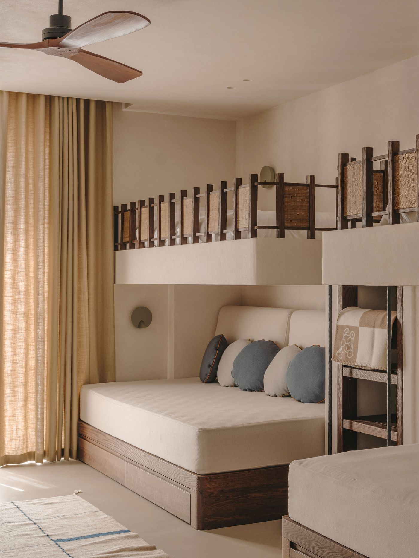 Cozy bedroom with a bunk bed, neutral tones, wooden accents, and plush cushions, illuminated by soft sunlight through sheer curtains. Cozy bedroom with a bunk bed, neutral tones, wooden accents, and plush cushions, illuminated by soft sunlight through sheer curtains.