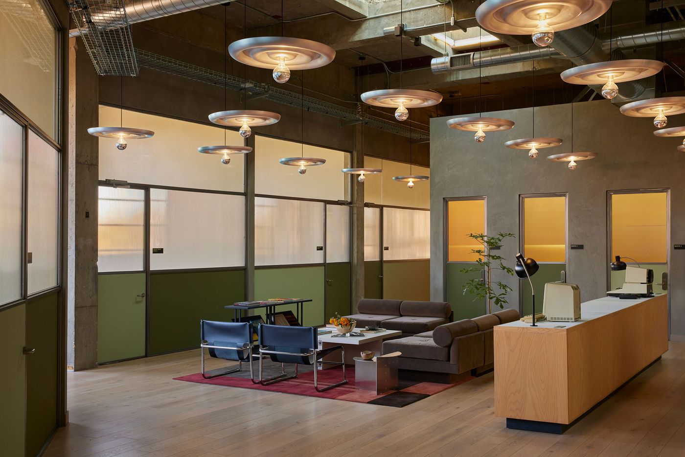 A modern office lobby featuring sleek furniture, artistic lighting, and green accents, creating a bright and inviting workspace. A modern office lobby featuring sleek furniture, artistic lighting, and green accents, creating a bright and inviting workspace.