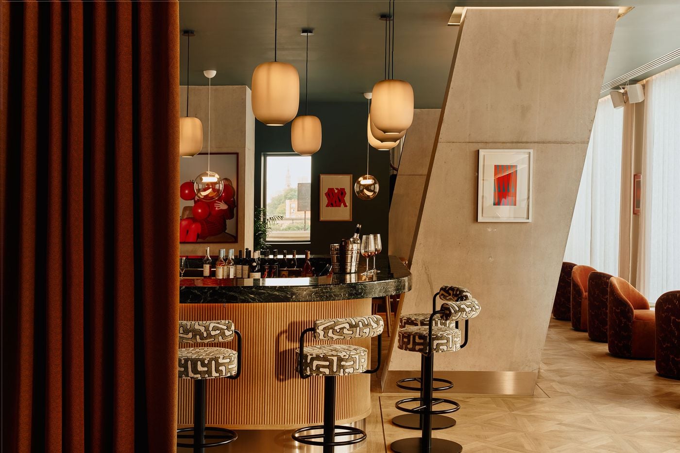 LUQA bar channels the polished atmosphere of a 1960s cocktail lounge through a curved counter clad in fluted timber and topped with dark green marble. Warm pendant lights, patterned stools and rust-coloured seating soften the surrounding concrete structure, balancing corporate-era sophistication with Locke’s more relaxed, sociable character. LUQA bar channels the polished atmosphere of a 1960s cocktail lounge through a curved counter clad in fluted timber and topped with dark green marble. Warm pendant lights, patterned stools and rust-coloured seating soften the surrounding concrete structure, balancing corporate-era sophistication with Locke’s more relaxed, sociable character.