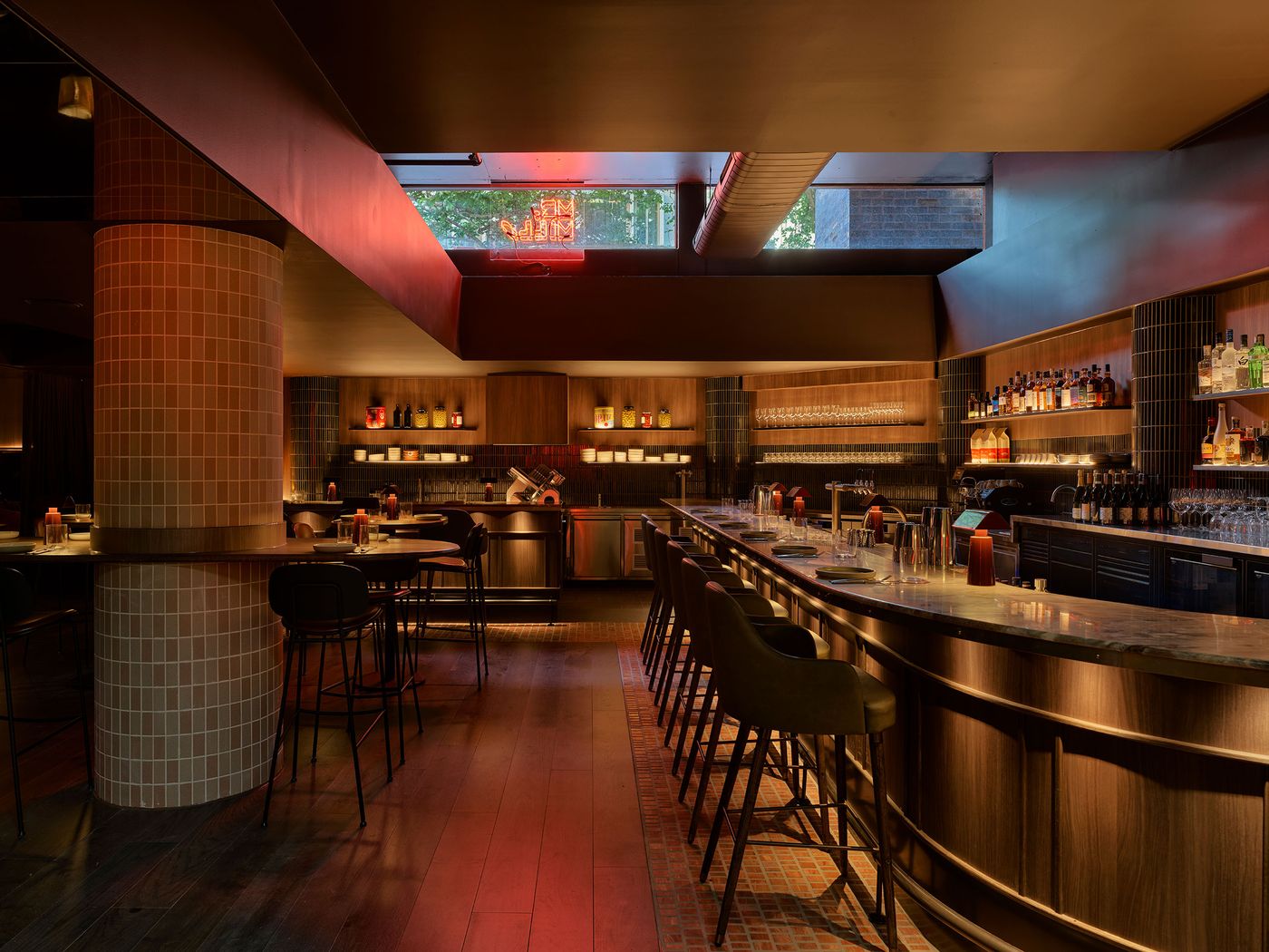 A stylish bar with a curved countertop, dark wood accents, and glowing shelves, illuminated softly by warm lighting and a neon sign. A stylish bar with a curved countertop, dark wood accents, and glowing shelves, illuminated softly by warm lighting and a neon sign.