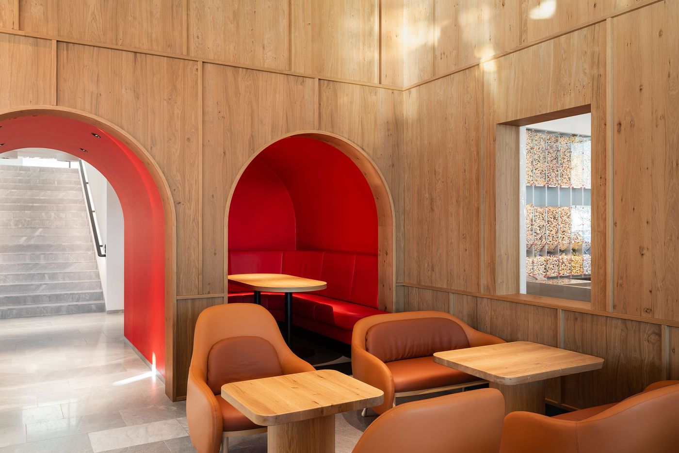 Red-lined archways frame intimate seating areas within timber-clad walls, creating theatrical moments of color punctuation. The interplay between natural wood textures and bold crimson accents establishes a distinctive brand identity while maintaining architectural sophistication through precise detailing and proportions. Red-lined archways frame intimate seating areas within timber-clad walls, creating theatrical moments of color punctuation. The interplay between natural wood textures and bold crimson accents establishes a distinctive brand identity while maintaining architectural sophistication through precise detailing and proportions.